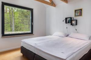 a large bed in a room with a window at Holiday Home by Lake Wise ka with Sauna in Wisełka