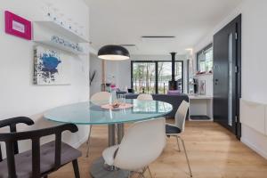 a dining room and living room with a glass table and chairs at Holiday Home by Lake Wise ka near Baltic Beach in Wisełka