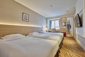 a hotel room with two beds and a window at Summit Hotel Seoul Dongdaemun in Seoul