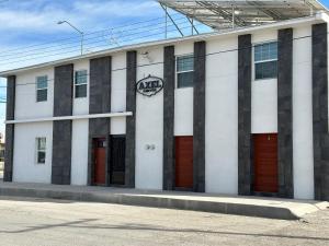 a building with red doors and a sign on it at AXEL Suites Departamento 1A in Delicias