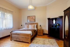 a bedroom with a large bed with a wooden headboard at Spacious Goldfields Retreat - Central & Charming in Castlemaine
