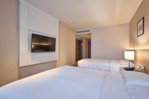 a hotel room with two beds and a flat screen tv at Summit Hotel Seoul Dongdaemun in Seoul