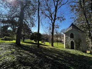 eine alte Steinkapelle in einem Park mit Bäumen in der Unterkunft Gîte d'exception à Lésigny - Charme et confort pour 5 personnes - FR-1-541-168 in Lésigny