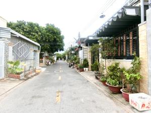an empty street with plants on the sides of buildings at Luan Hoa Homestay in Ấp Bình Hưng