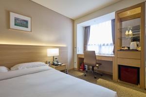 a hotel room with a bed and a desk and a window at Summit Hotel Seoul Dongdaemun in Seoul +71 photos