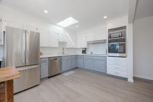 a kitchen with white appliances and blue cabinets at Cozy 3-bedroom house, ocean view, walk to beach! in El Granada