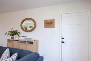 a living room with a blue couch and a mirror at Cozy 3-bedroom house, ocean view, walk to beach! in El Granada