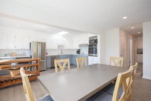 a white kitchen with a table and chairs at Cozy 3-bedroom house, ocean view, walk to beach! in El Granada +48 photos