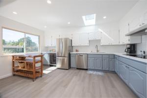 a large kitchen with blue cabinets and a table at Cozy 3-bedroom house, ocean view, walk to beach! in El Granada