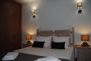 a bedroom with a bed with two lamps on two tables at Apartamento Oceano in Albufeira