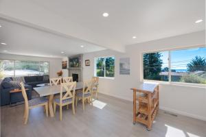 a living room with a table and chairs and a couch at Cozy 3-bedroom house, ocean view, walk to beach! in El Granada