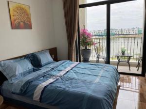 a bedroom with a bed with a view of a balcony at TC Apartment & Homestay 2 in Xóm Niêm