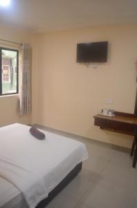 a bedroom with a bed and a television on the wall at SOUTH BAY Hotel in Klang