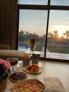 una mesa con platos de comida en una mesa con ventana en Hawana Salalah, en Salalah