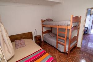 a bedroom with two bunk beds and a bed at Casa Sutar Los Pimientos in San Pedro de Atacama