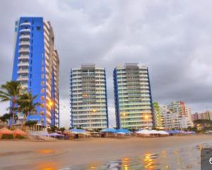 a city with tall buildings and umbrellas on a beach at GRAND DIAMOND BEACH Tonsupa Atacames in Tonsupa