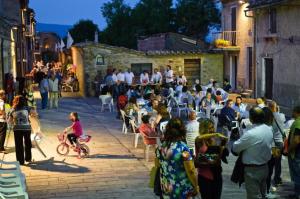 a crowd of people sitting in chairs in a street at Umbria nel cuore in Cannara