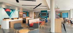 a lobby with chairs and tables and a cafeteria at avid hotel Lexington - Hamburg Area by IHG in Lexington +13 photos