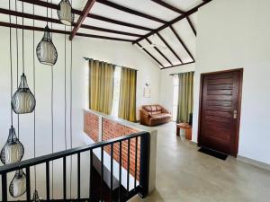 a living room with a staircase and a leather chair at Rasika Villa in Sri Jayewardenepura Kotte