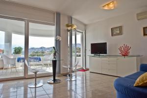 een woonkamer met een tv en een blauwe bank bij Villa Perla Baska in Baška