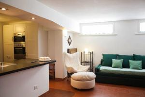 a living room with a green couch and a kitchen at L'appartamento di Monica in Casal Palocco