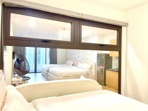 una sala de estar con dos camas y un sofá en TYE APARTMENT - TMS Pullman Quy Nhơn, en Quy Nhon