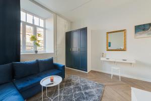 a living room with a blue couch and a table at Brand New Luxury Apartment, Parking, Center in Vilnius