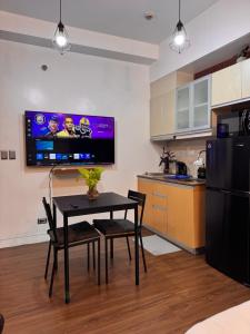 una cucina con tavolo e TV a parete di Condo in Mckinley Hill Taguig a Manila Altre 4 foto