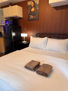 una camera da letto con un letto con due asciugamani sopra di Condo in Mckinley Hill Taguig a Manila
