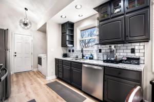 eine Küche mit schwarzen Schränken und einem Fenster in der Unterkunft Serenity Cottage 300mbps Wifi - Dog Friendly in Clarksville