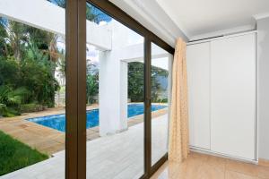 a view of a pool from a house with sliding glass doors at Private, Cosy and Stylish Stay at Nest24 Evans Park in Johannesburg