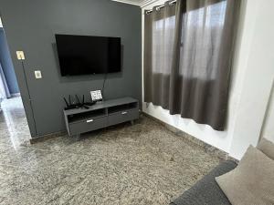 a living room with a flat screen tv on a wall at Cobertura de Frente Para o Mar e Piscina Village das Ondas in Piúma