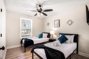 2 Betten in einem Zimmer mit Deckenventilator in der Unterkunft Serenity Cottage 300mbps Wifi - Dog Friendly in Clarksville