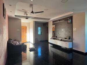 a living room with a couch and a ceiling fan at Deqorum villas in Kumbakonam