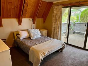 a bedroom with a bed and a sliding glass door at The Summer House - Pet friendly outside in Robe