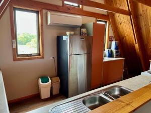 una cucina con frigorifero in acciaio inox e lavello di The Summer House - Pet friendly outside a Robe