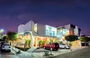 a building with cars parked in a parking lot at Studios V19 in Colima