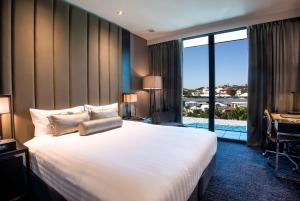 a hotel room with a large bed and a large window at The Beetson Hotel in Brisbane