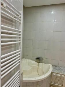 a white bath tub in a bathroom with white tiles at Maison azur in Tunis +7 photos