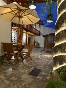 a patio with a table and chairs with an umbrella at Bellavista Bed & Breakfast in Cajamarca