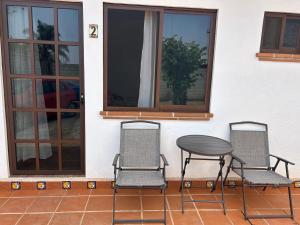 two chairs and a table in front of a house at casa regina in Tepoztlán
