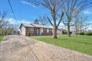 ein Haus mit einem Baum im Vorgarten in der Unterkunft Serenity Cottage 300mbps Wifi - Dog Friendly in Clarksville