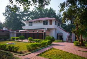 a white house with a garden in front of it at Palamau Tiger Reserve Eco Habitat in Kechki