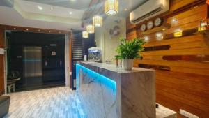 a lobby with a counter with a potted plant on it at Hotel Ashraya International in Mumbai