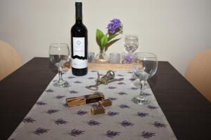 una mesa con una botella de vino y dos copas de vino en Apartments Lavendula, en Vodice