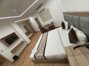 a hotel room with a large bed and a television at Metropolitan Inn IGI Airport New Delhi in New Delhi