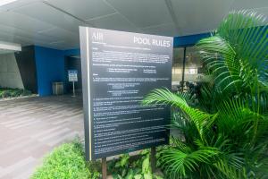 马尼拉Alice in Wonderland Enchanting Makati Retreat 300 Mbps的建筑物前的标志，有植物