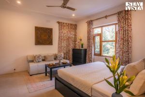 a bedroom with a bed and a couch at StayVista at Hampton Grove - Bonfire, Jacuzzi in Srinagar