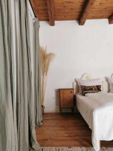 a bedroom with a bed and a wooden ceiling at Lelle Cottage in Balatonlelle