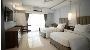 een hotelkamer met twee bedden en een televisie bij Arbian Sea Country Club in Karachi +20 foto's